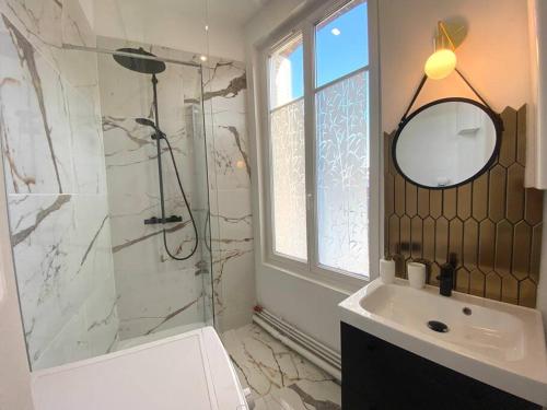 uma casa de banho com um chuveiro, um lavatório e um espelho. em The Jungle Flat em Rouen