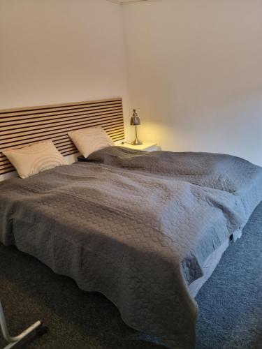 - une chambre avec un grand lit et une tête de lit en bois dans l'établissement Tæt på Centrum & MCH/Boxen - Huset nr. 11, à Herning