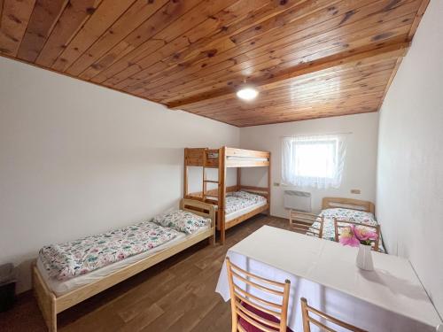 a room with two bunk beds and a table at Penzion Hevera in Kuchařovice