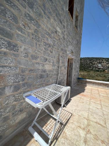 a white bed sitting against a brick wall at MANI Kamares Beach House in Gythio