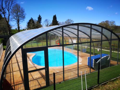 a swimming pool in a domed building with a swimming pool at Le Domaine du Scorff - hébergements insolites chalets 4 à 6 personnes et roulottes in Kernascléden