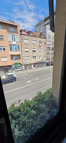 a window with a view of a street with buildings at Villa 1927 in Belgrade