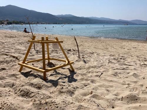 a wooden lifeguard stand on a beach with the water at Ayïa suites in Alikanas