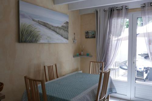d'une salle à manger avec une table et une porte coulissante en verre. dans l'établissement Villa située entre mer et forêt, à Grand-Village-Plage