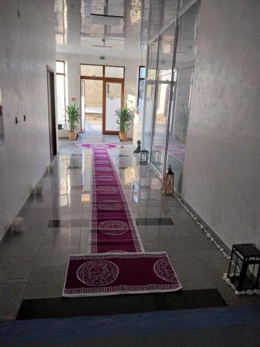 a hallway with red carpets on the floor of a building at Медицински Център Аюрведа in Sveti Vlas