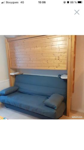 - un lit dans une chambre avec une tête de lit en bois dans l'établissement Studio à la montagne / Sommand/Praz-de-Lys, à Mieussy