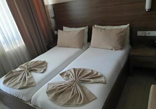 two beds in a hotel room with bows at Plaj resort dorra in Buyukcekmece