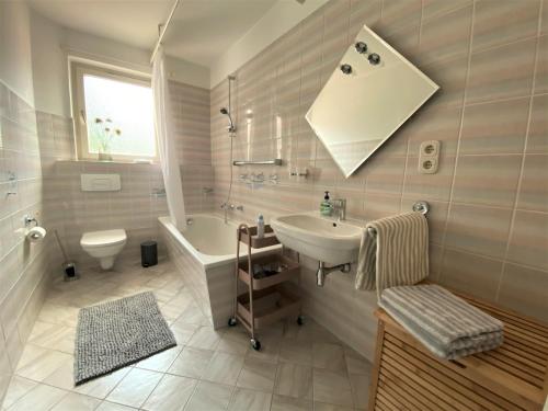 bagno con lavandino, vasca e servizi igienici di Erholsames Wohnen in Bad Bramstedt Appartement III a Bad Bramstedt