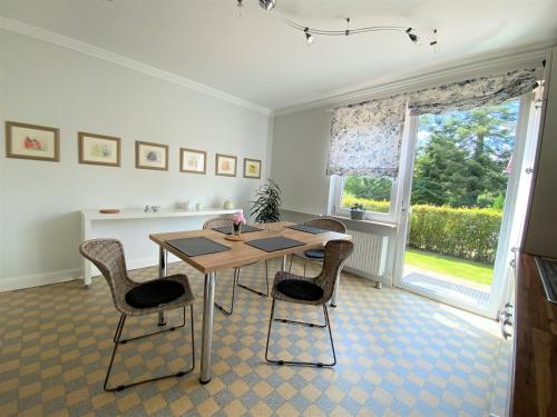 una sala da pranzo con tavolo, sedie e finestra di Erholsames Wohnen in Bad Bramstedt Appartement III a Bad Bramstedt