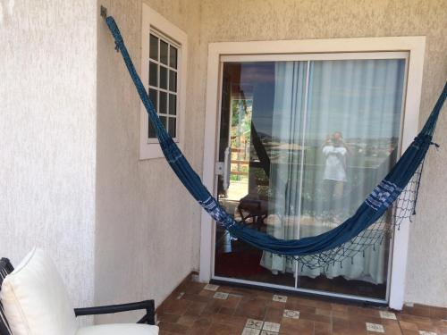 eine Hängematte, die in einem Zimmer neben einem Fenster hängt in der Unterkunft Cruzeiro in São Pedro da Aldeia