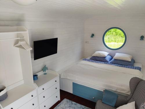 a small bedroom with a bed and a window at Maringotka Nebeská in Chýnov