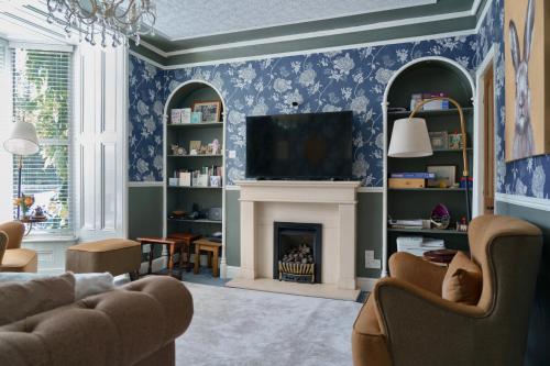 a living room with a fireplace and a tv at The Cottage - Room Only in Windermere