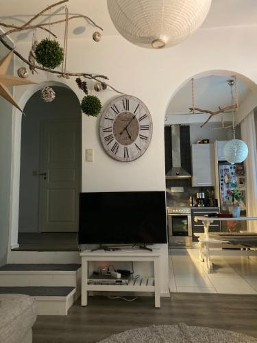 a living room with a large clock on the wall at Kolmio luhtitalossa in Savonlinna