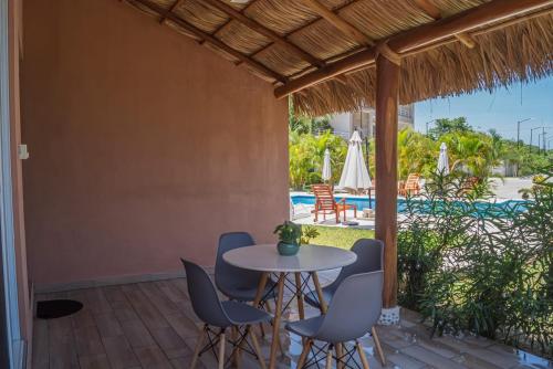 a patio with a table and chairs and a pool at Residencial San Agustin Huatulco in Santa Cruz Huatulco