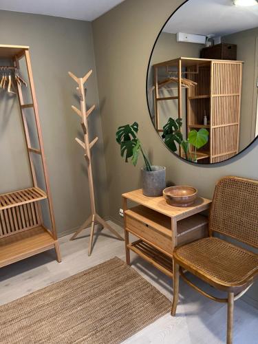 Zimmer mit einem Spiegel, einem Stuhl und einem Tisch in der Unterkunft Koselig leilighet på Bystranden in Kristiansand