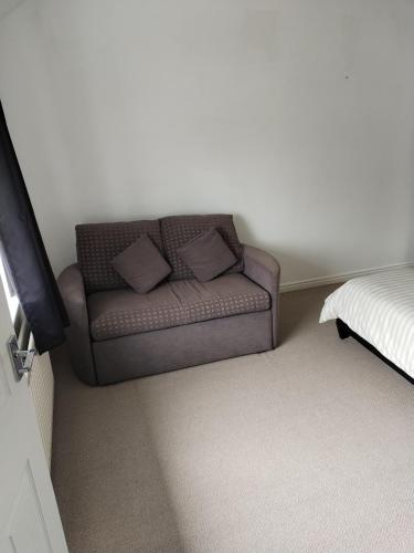 a couch in the corner of a room with a bed at Flat sleeps 5 people in Guisborough in Guisborough