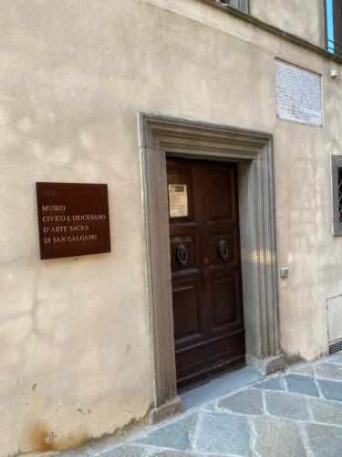 a building with a brown door with a sign on it at Casa Nonna Rina in Chiusdino