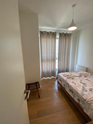 a bedroom with a bed and a window with curtains at Verde 18 in Sajmište