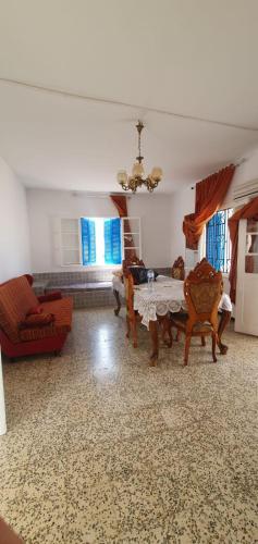 un grand salon avec une table et des chaises dans l'établissement Chouette villa au bord de la plage hergla, à Sousse