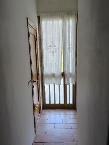 a hallway with a door and a window with curtains at Casa Le Piane in Strettura