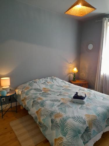 a bedroom with a bed in a room with a window at La maison aux volets bleus in Le Vigean