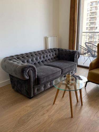 a living room with a couch and a glass table at Verde 18 in Sajmište