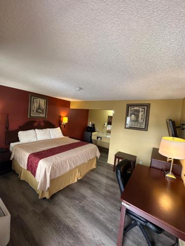 um quarto de hotel com uma cama grande e uma secretária em Wye Motel em Clinton