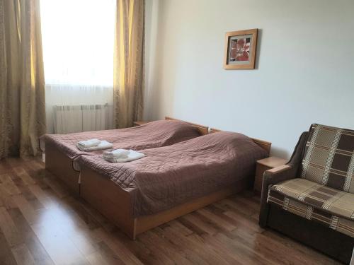 a small bedroom with a bed and a chair at Villa Kameliya in Truskavets