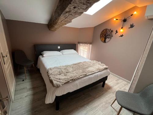 a bedroom with a bed and a chair in it at Gîte de charme avec terrasse in Fleurie