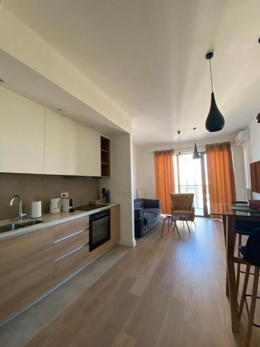 a kitchen and living room with a table and chairs at Verde 18 in Sajmište