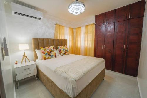 ein Schlafzimmer mit einem großen Bett, einem Nachttisch und einem Schrank in der Unterkunft Luxury & Private Apartment in Mendoza