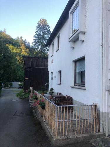 a white building with a fence in front of it at Ferienwohnung Schlossberg 1 in Wirsberg