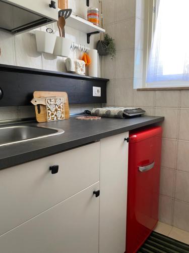 una cocina con un armario rojo junto a un fregadero en B&B “il Pellicano”, en Policoro