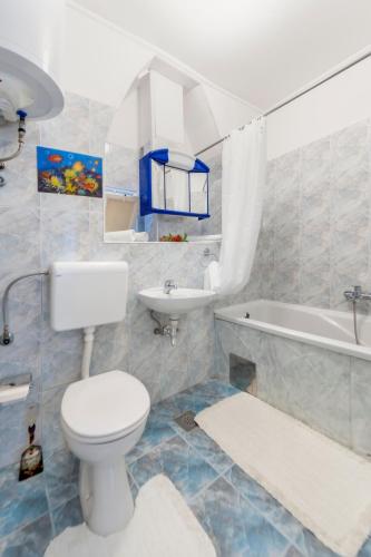 a bathroom with a toilet and a sink and a tub at Rovinj Romance Apartment in Rovinj