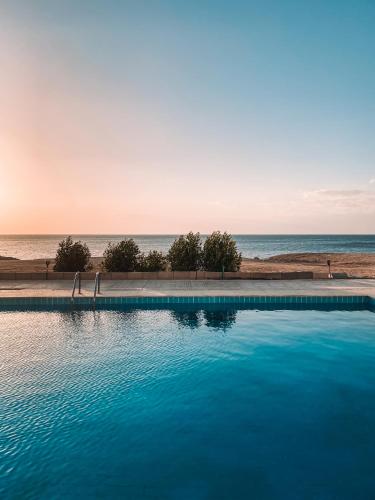 a swimming pool with the ocean in the background at Serenity Lodge in Sharm El Sheikh