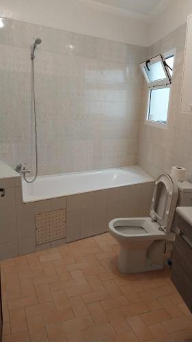 a bathroom with a tub and a toilet and a shower at Charmant appartement in Al Hoceïma