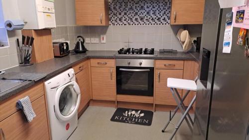 a kitchen with a washing machine and a refrigerator at 3 bedroom Brixton Apartment in London