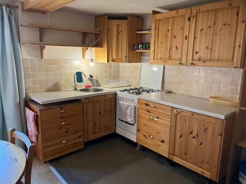 a kitchen with wooden cabinets and a stove top oven at Beautiful Swiss chalet with breathtaking views and a sauna 