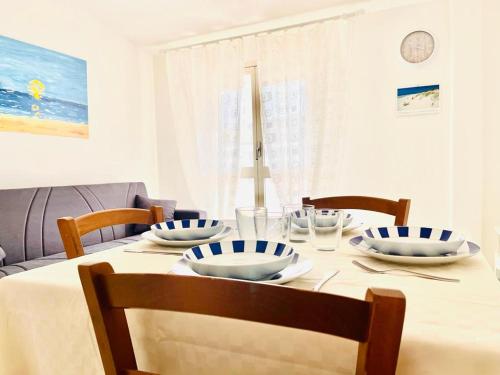 tavolo da pranzo con sedie e piatti di Daruma Apartment a Siniscola