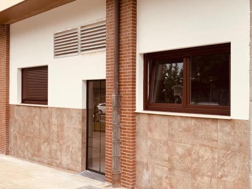 um edifício de tijolos com uma porta e janelas em LAGA&LAIDA APARTAMENTOS GERNIHOST en Urdaibai em Guernica y Luno