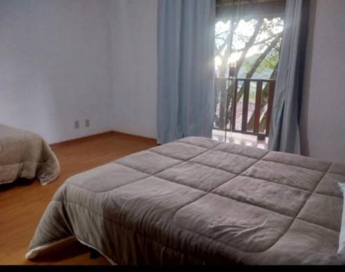una camera con un grande letto e una finestra di PousadaTopFest a Poços de Caldas