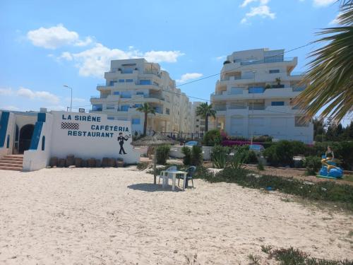 ein Schild am Strand vor einem Gebäude in der Unterkunft Lilia's house Al Kantaoui in Sousse