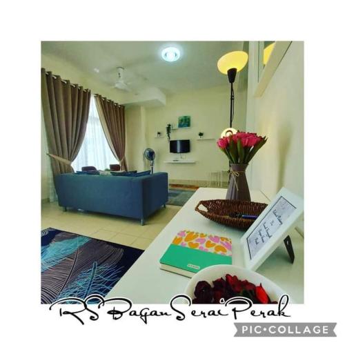 a living room with a blue couch and a table at Rumah Singgah Bagan Serai Perak in Bagan Serai