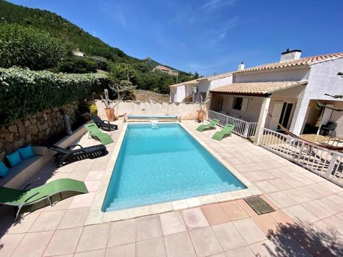 une piscine avec des chaises et une maison dans l'établissement Villa de charme Porto-Vecchio, Plage à 10 min, à San-Gavino-di-Carbini