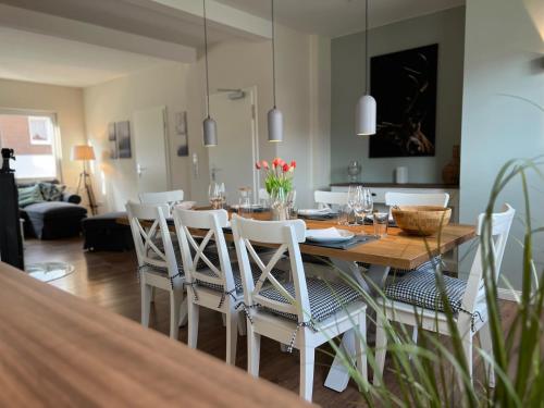 een eetkamer met een tafel en witte stoelen bij Haus auf dem Berg in Braunlage