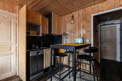 une cuisine avec un comptoir noir et des tabourets dans l'établissement La haut, dans les montagnes ..., à Corrençon-en-Vercors