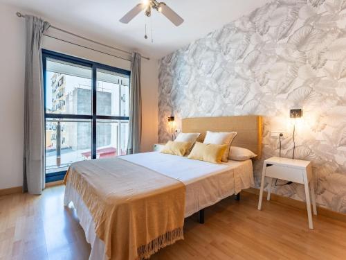 ein Schlafzimmer mit einem großen Bett und einem großen Fenster in der Unterkunft Faro's Malaga Citylights - Amazing Roof Terrace in Málaga