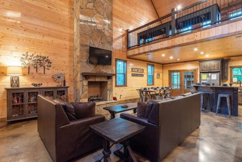 a living room with couches and a bar in a cabin at Centrally Located Lux Cabin with Hot Tub, Fire Pit, EV Outlet in Broken Bow