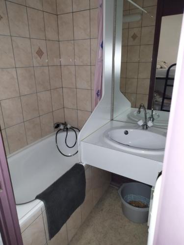 une salle de bain avec un lavabo, une baignoire et un miroir dans l'établissement Studio à vars, à Vars