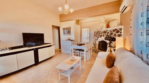 a living room with a couch and a tv at Orionas in Tsoútsouros
